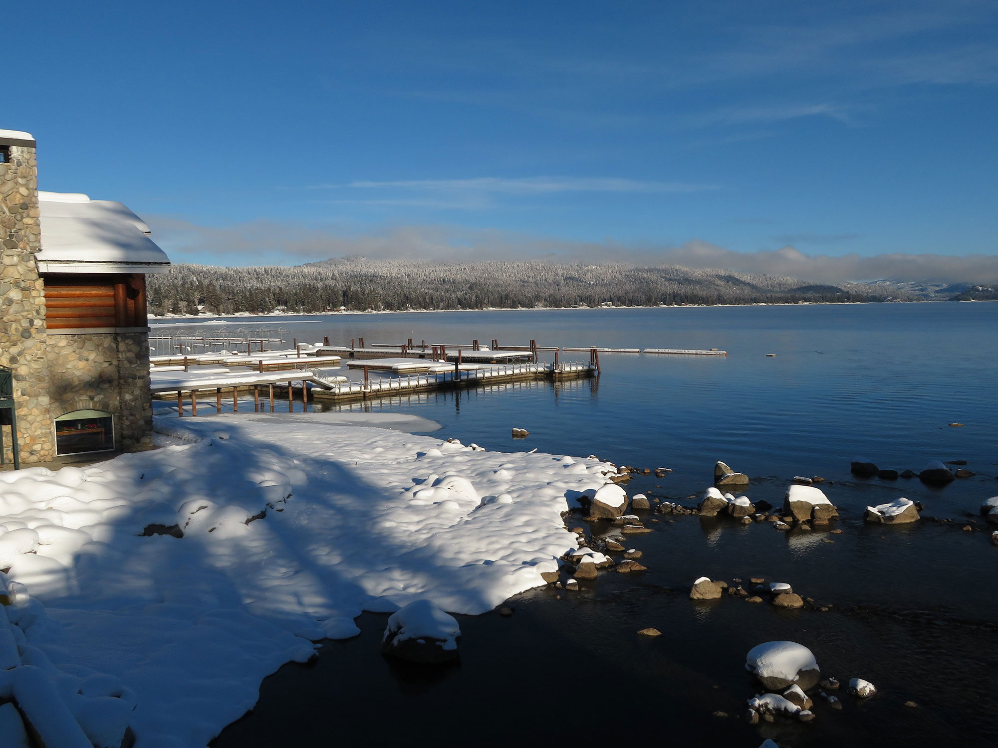 Payette Lake in McCall Idaho during winter with snow-covered shoreline and calm mountain lake water