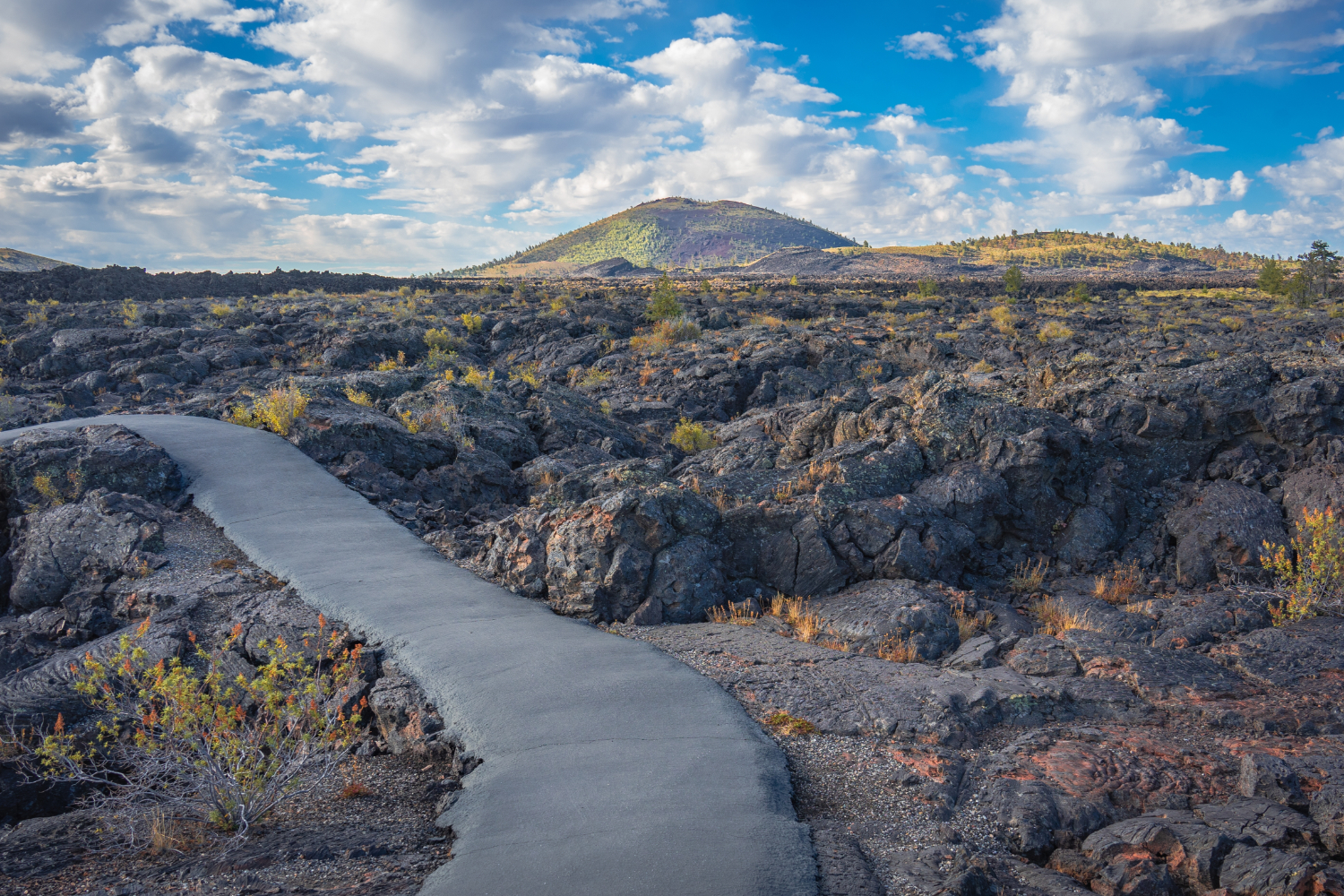 Craters of the Moon National Monument in Idaho with paved trail through volcanic lava fields and cinder cones