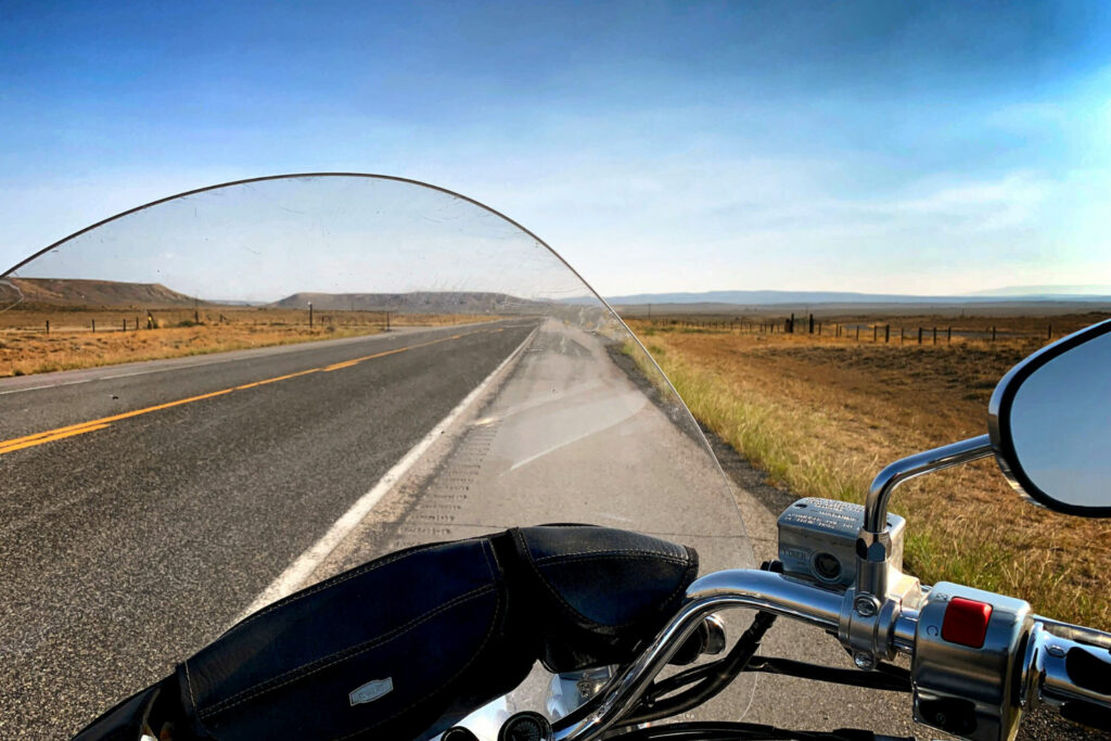 View of open highway in southern Idaho from a motorcycle with wide desert landscape