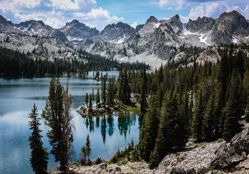 Alice Lake in Idaho’s Sawtooth Mountains surrounded by pine forest and rugged alpine peaks