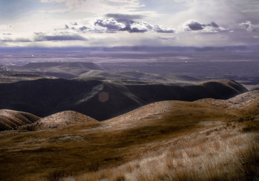 rolling hills of the Boise Foothills overlooking the Treasure Valley with dramatic clouds and open landscape