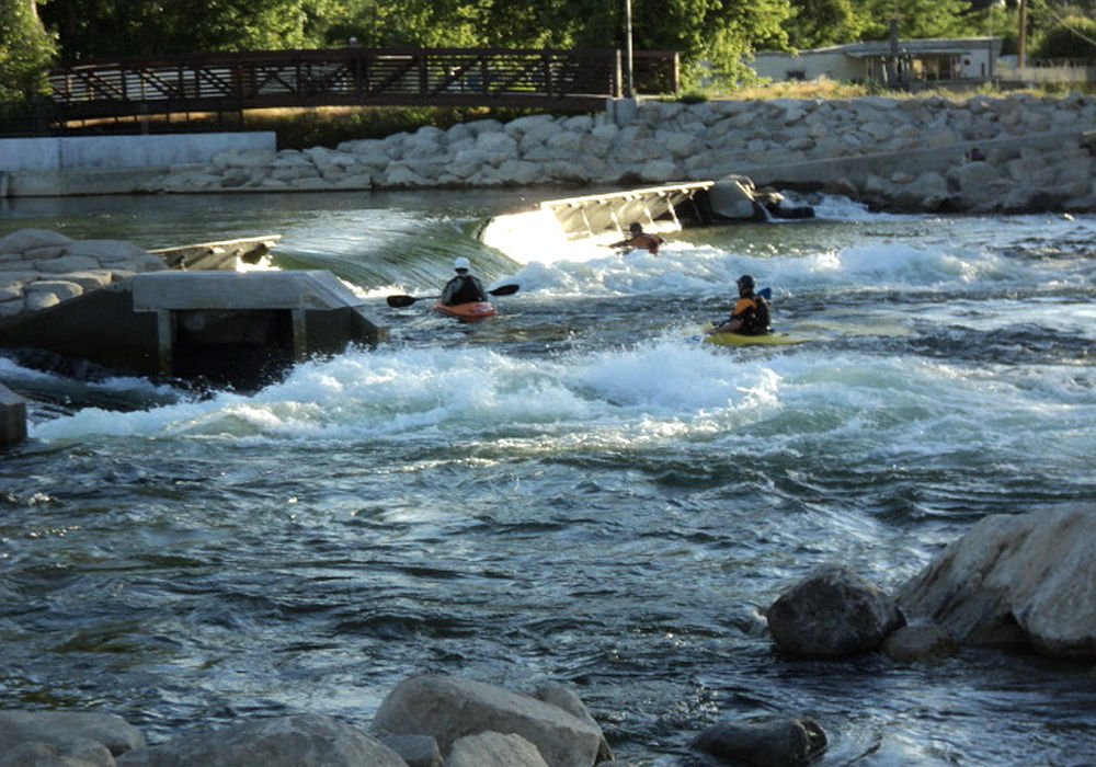 Kayakers navigating rapids at Boise Whitewater Park in Idaho along the Boise River