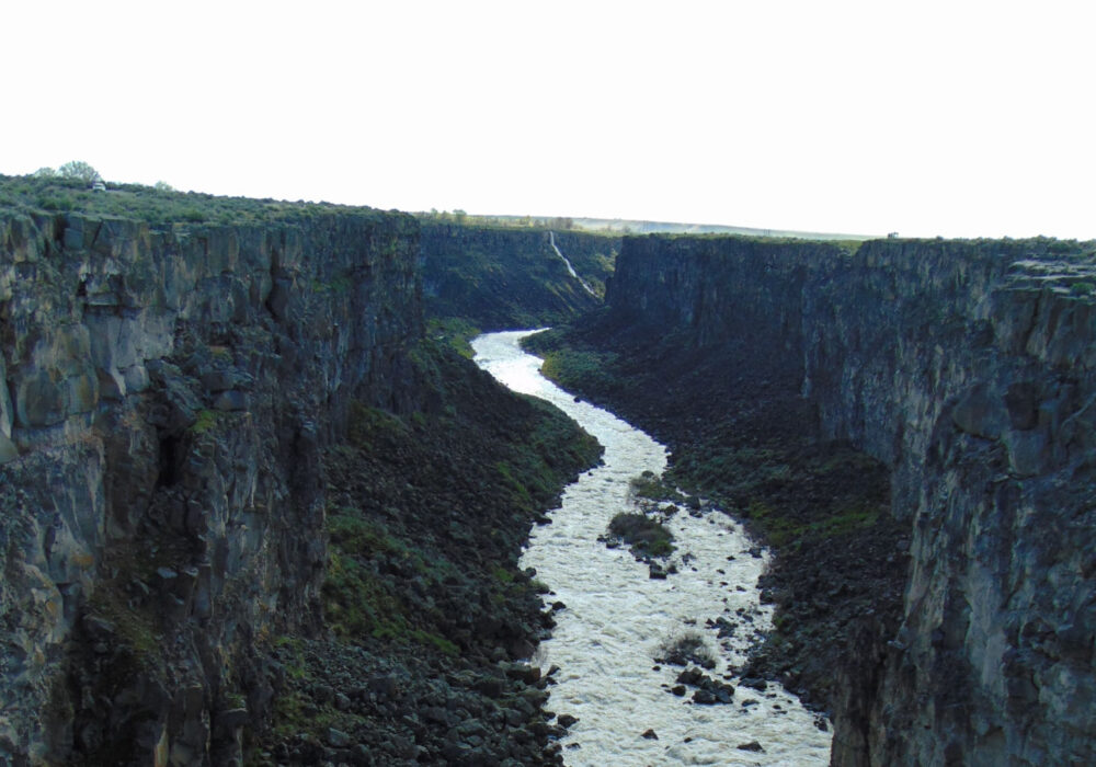 Malad Gorge State Park in Idaho with a deep basalt canyon and fast-moving river below steep cliffs