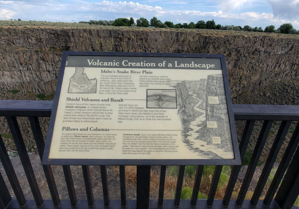 Informational sign about volcanic landscape formation overlooking Malad Gorge canyon and river in Idaho