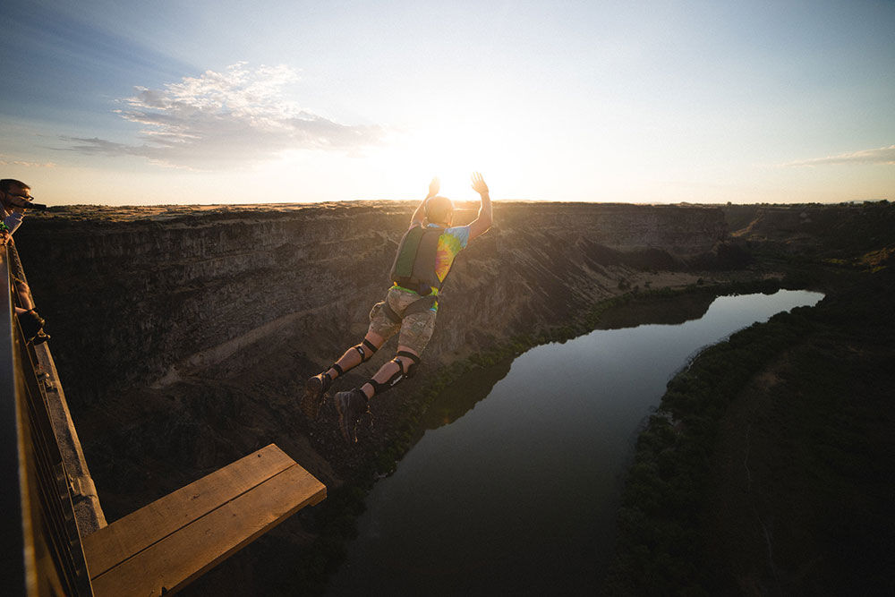 base jumper leaping from Perrine Bridge over Snake River Canyon in Twin Falls Idaho at sunset