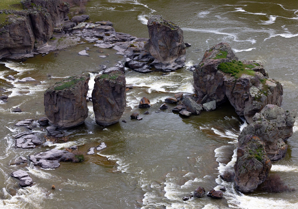 Pillar Falls rock formations in Snake River near Twin Falls Idaho with flowing water around canyon pillars