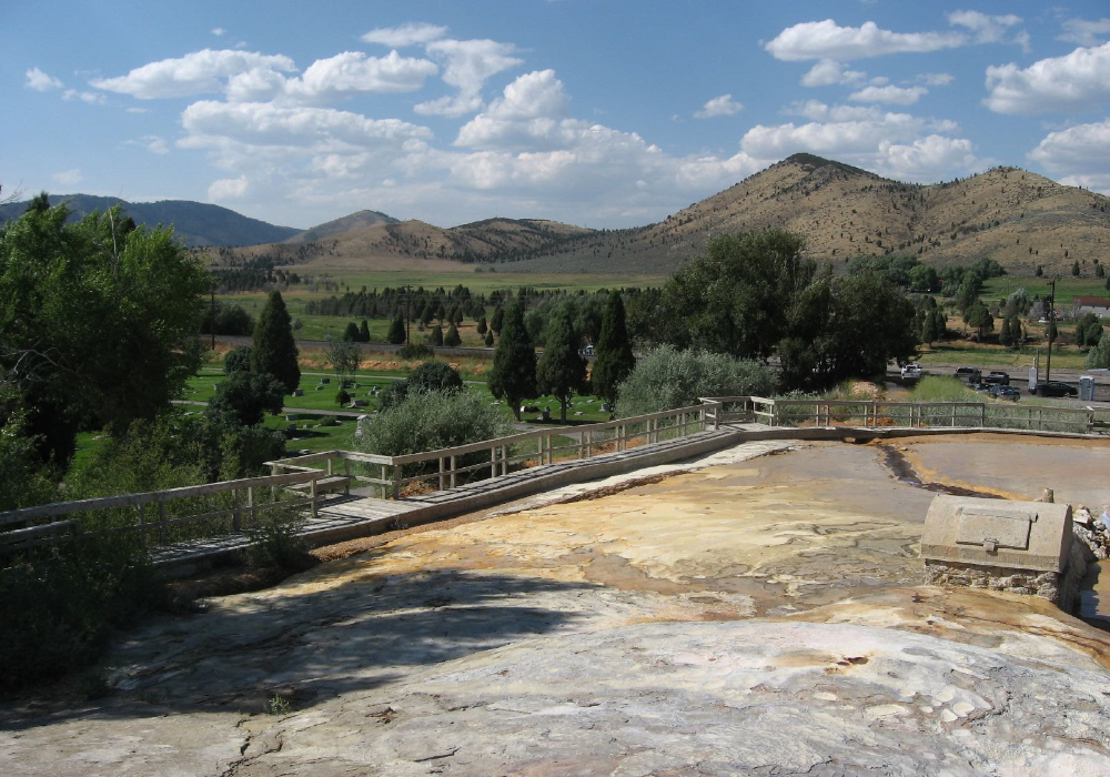 Landscape view of Soda Springs Geyser site in Idaho with boardwalk and valley backdrop, one of Idaho’s unique attractions