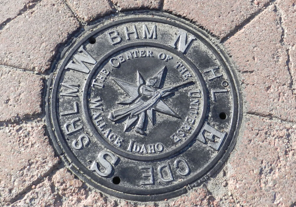 center-of-the-universe-wallace-idaho-marker Center of the Universe marker embedded in the sidewalk in Wallace, Idaho with engraved compass design and historic mining town reference