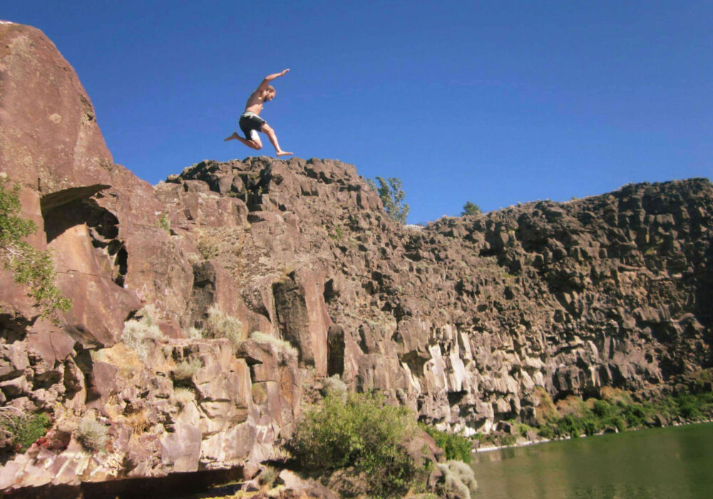 cliff-jumping-dierkes-lake-twin-falls-idaho Person cliff jumping into the water at Dierkes Lake near Twin Falls, Idaho surrounded by rocky canyon cliffs