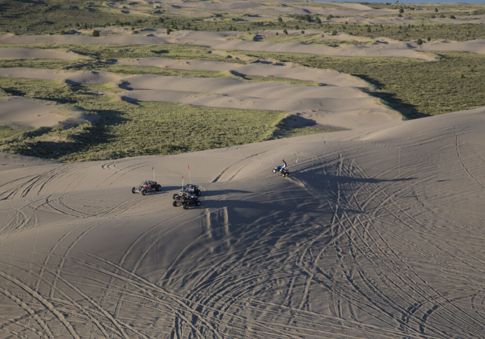 st-anthony-sand-dunes-idaho ATVs and off-road vehicles riding across the rolling sand dunes at St. Anthony Sand Dunes near St. Anthony, Idaho