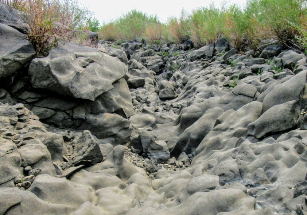 black-magic-canyon-shoshone-idaho Eroded volcanic rock formations in Black Magic Canyon near Shoshone, Idaho, featuring smooth basalt walls sculpted by centuries of flowing water.