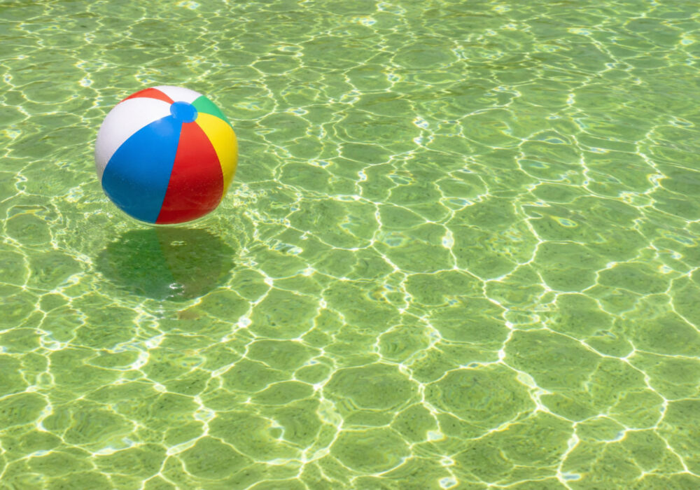 nat-soo-pah-hot-springs Colorful beach ball floating on the clear mineral water at Nat-Soo-Pah Hot Springs in Idaho, with sunlight creating shimmering reflections across the pool surface.
